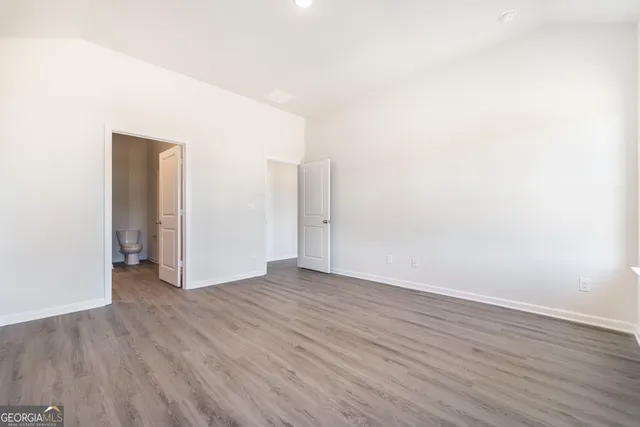 an empty room with wooden floor and closet
