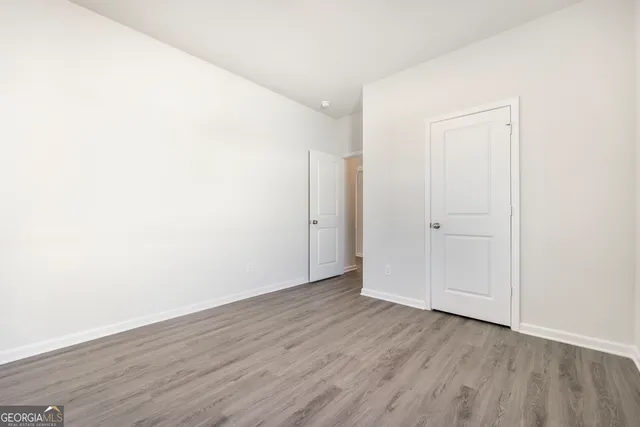 a view of an empty room with wooden floor