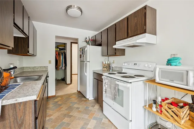 a kitchen with stainless steel appliances granite countertop sink stove top oven and cabinets