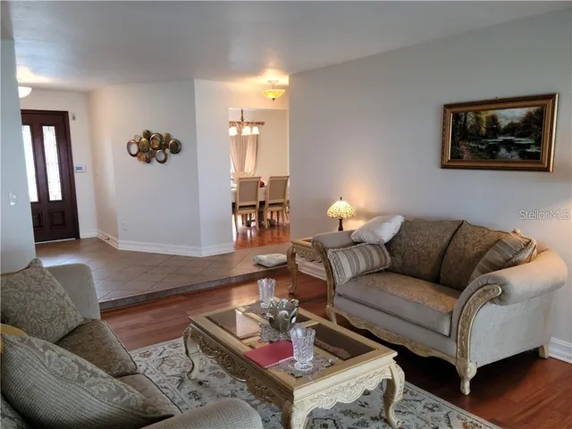 a living room with furniture and a ceiling fan