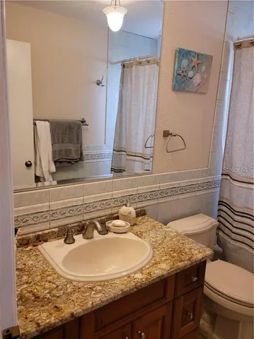 a view of a big room with windows and chandelier fan