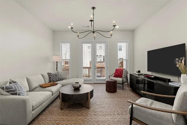a living room with furniture a chandelier and a flat screen tv