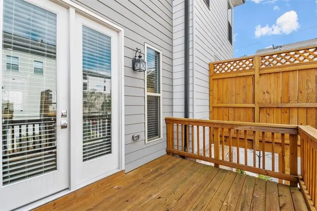 a view of a wooden balcony with a floor to ceiling window