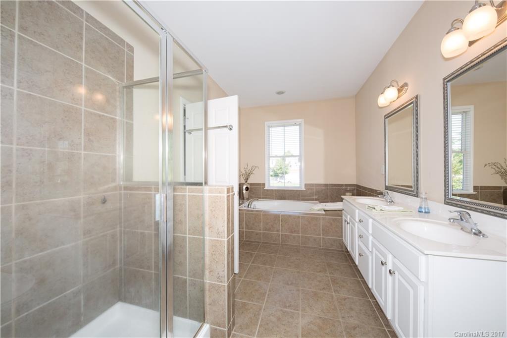 607 Caspar Way Fort Mill, SC 29708 - Photo 17 of 24 a bathroom with a double vanity sink and mirror with bathtub