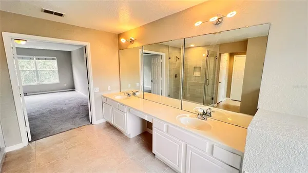 a bathroom with double vanity and a shower