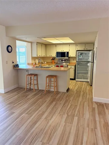 a kitchen with a sink and wooden floor