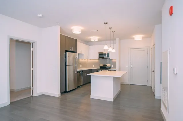 a kitchen with kitchen island a sink stainless steel appliances and refrigerator