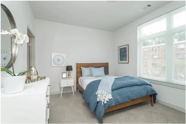 a bedroom with a bed mirror and window