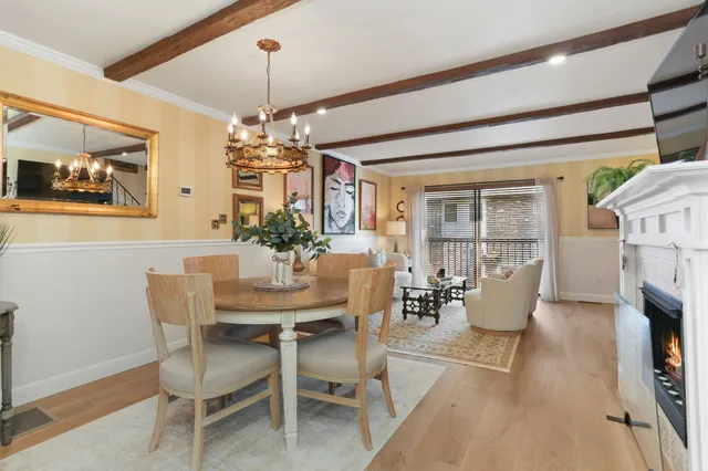 a dining room with furniture a chandelier and wooden floor