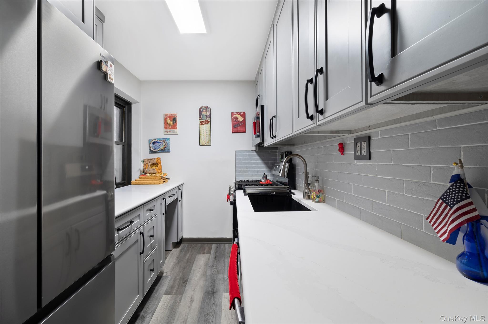 82-35 134th Street, Unit 3G Queens, NY 11435 - Photo 2 of 7 a kitchen with stainless steel appliances a sink a refrigerator and a stove