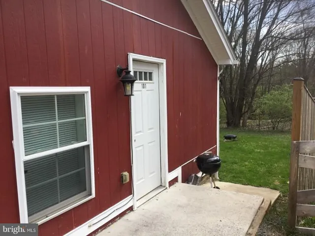 a view of a backyard with a chair and potted plants