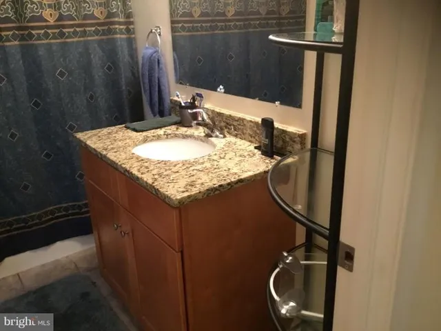 a bathroom with a granite countertop sink and a mirror