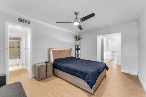 a bedroom with a large bed and a chandelier fan
