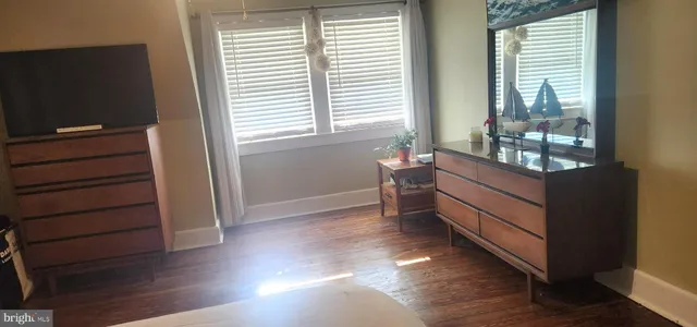 a room with wooden floor and windows