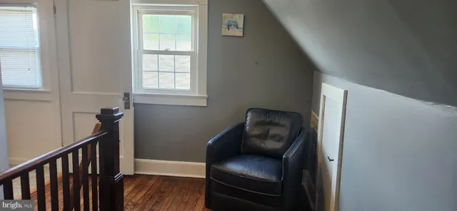a view of a hallway with wooden floor and a workspace