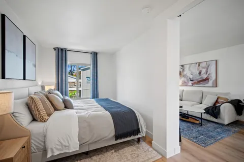 a bedroom with a bed and wooden floor