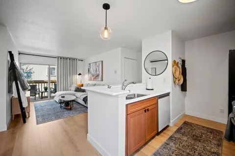 a kitchen that has a sink a stove and a wooden floor