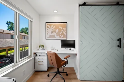 a work place with a desk and chair with a bookshelf