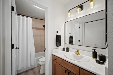 a bathroom with a granite countertop sink toilet and shower