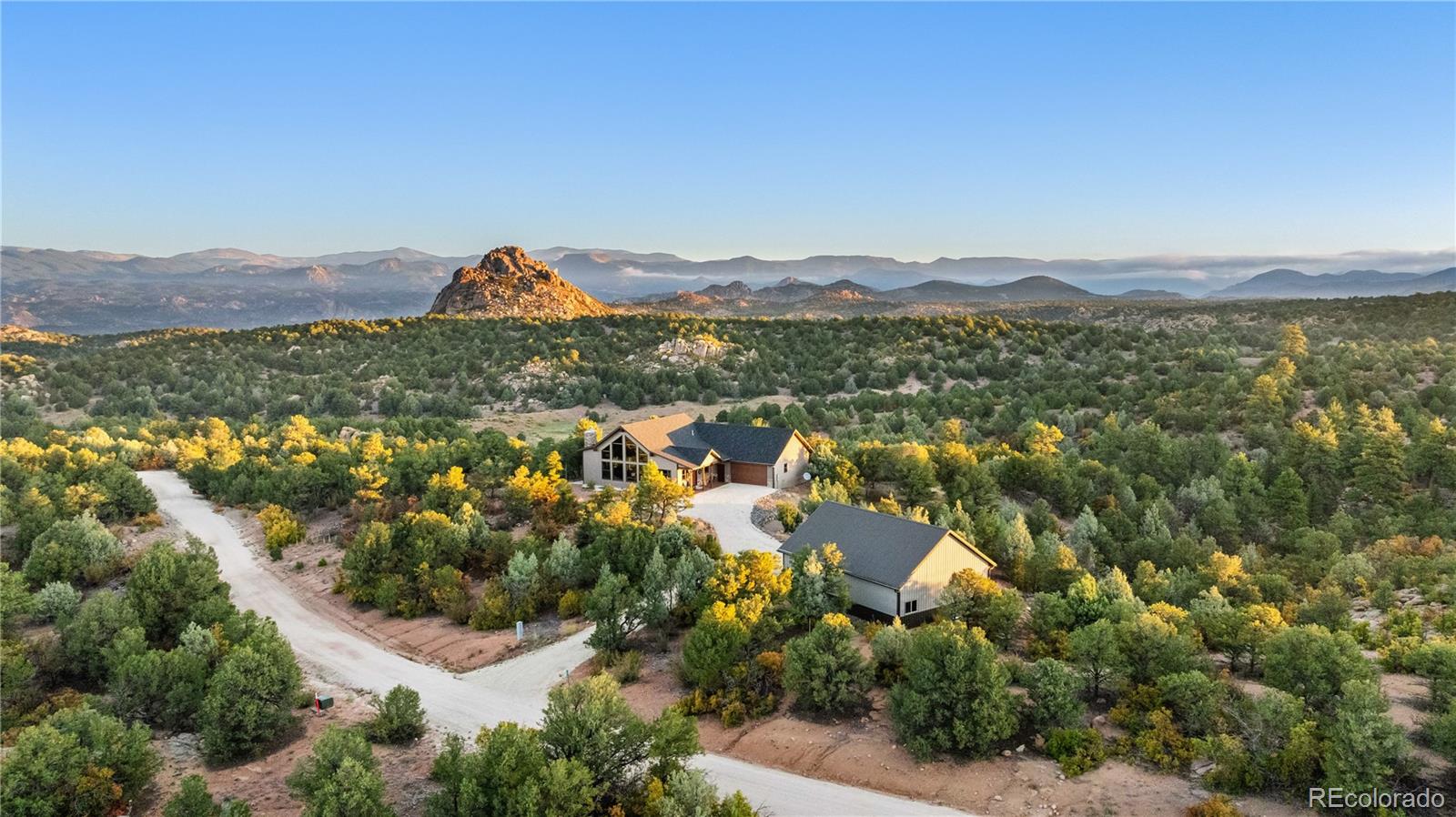 an aerial view of residential house with outdoor space and trees all around