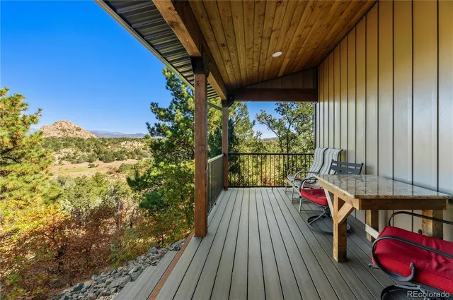 a living room with furniture a chandelier and a floor to ceiling window