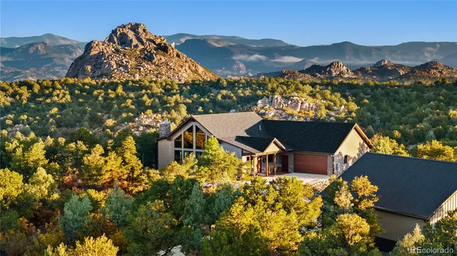 a view of a house with a mountain and a forest