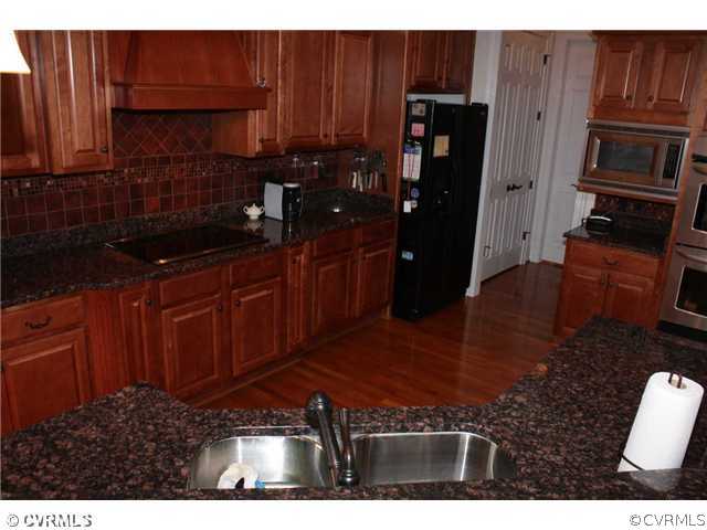 4018 Bircham Loop Midlothian, VA 23113 - Photo 3 of 12 a kitchen with stainless steel appliances granite countertop wooden cabinets a refrigerator and a sink