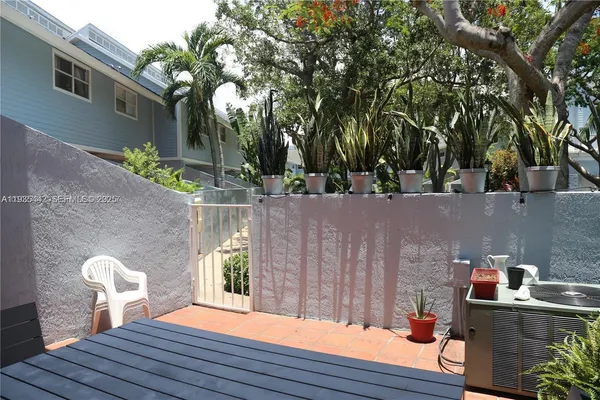 a view of a house with a chairs and table in a patio
