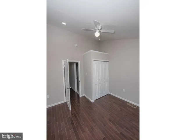 a view of a room with wooden floor and ceiling fan