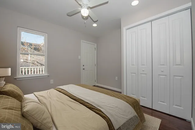 a bedroom with a large bed and a chandelier fan