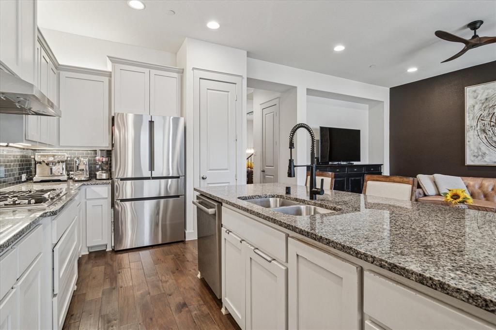 7919 Canal Street Frisco, TX 75034 - Photo 12 of 36 a kitchen with kitchen island granite countertop appliances cabinets a sink and a counter top space