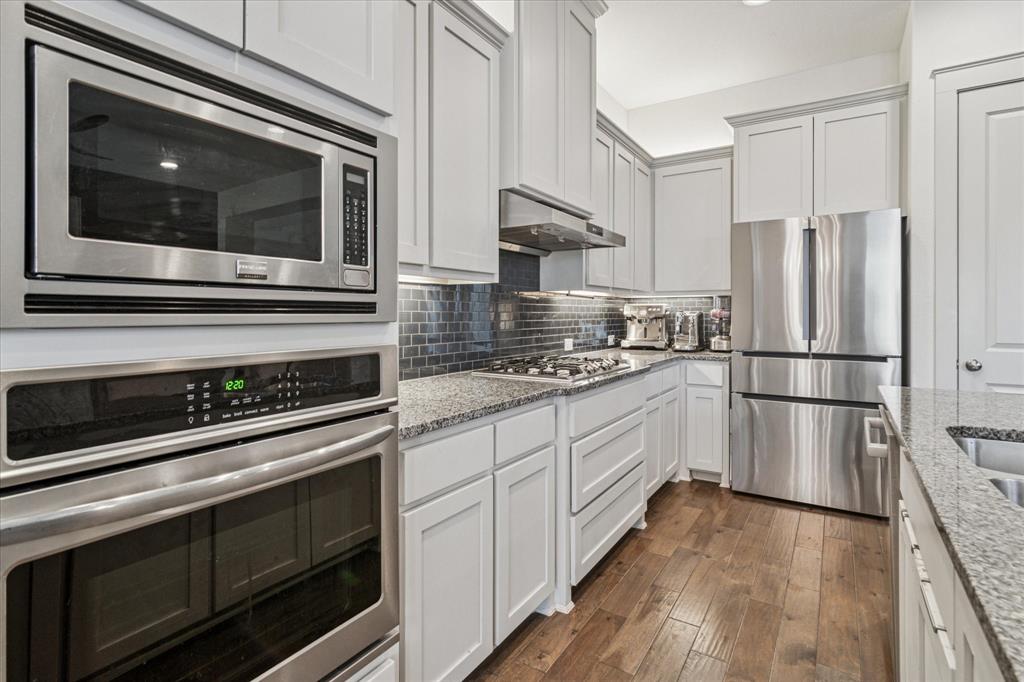 7919 Canal Street Frisco, TX 75034 - Photo 14 of 36 a kitchen with stainless steel appliances white cabinets and stove
