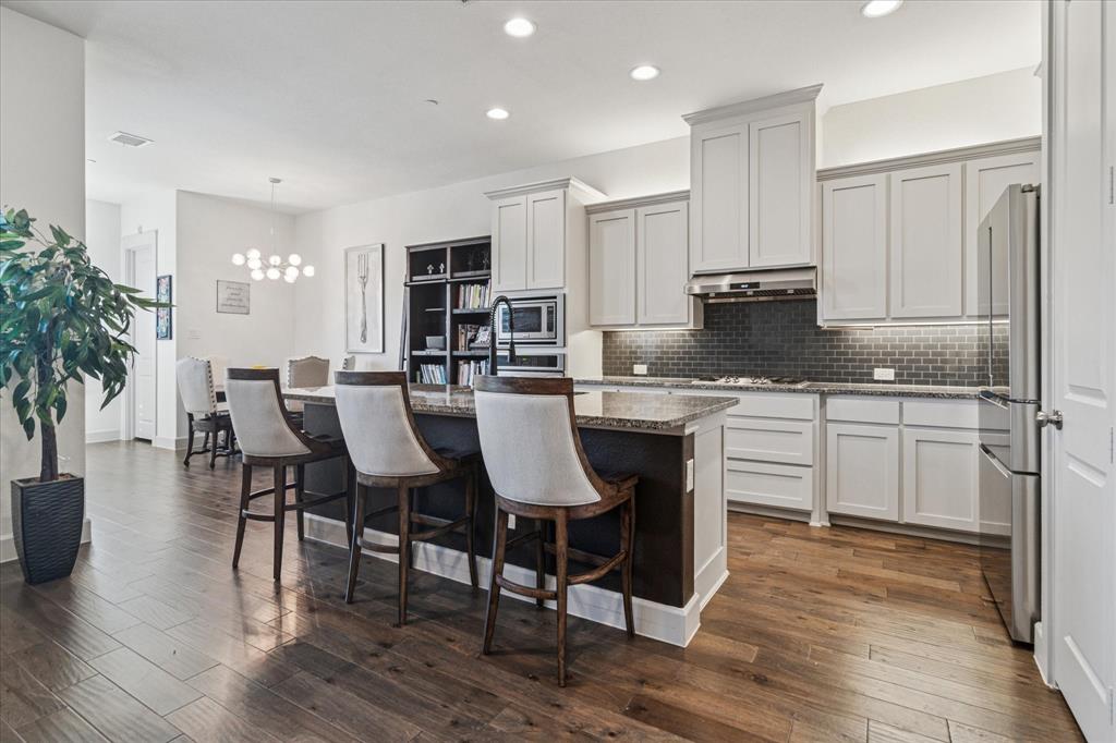7919 Canal Street Frisco, TX 75034 - Photo 15 of 36 a kitchen with a table chairs stove and cabinets