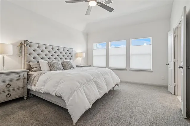 a large bed sitting in a bedroom next to a window
