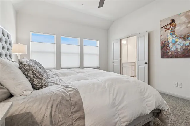 a large bed sitting in a bedroom next to a window
