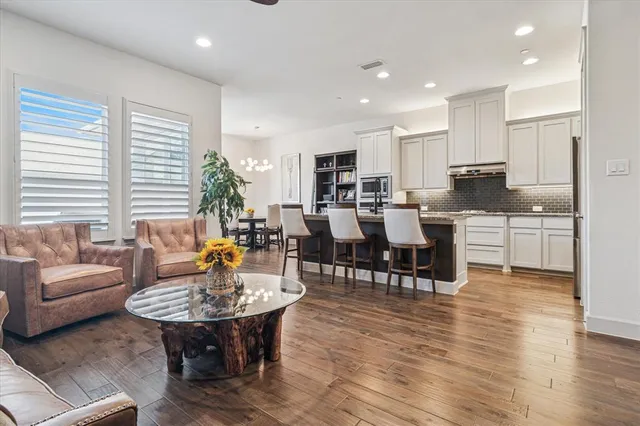 a living room with lots of furniture and kitchen view