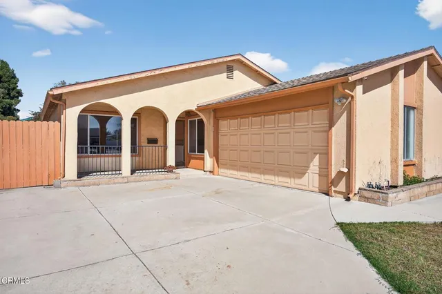 a view of house with backyard and parking