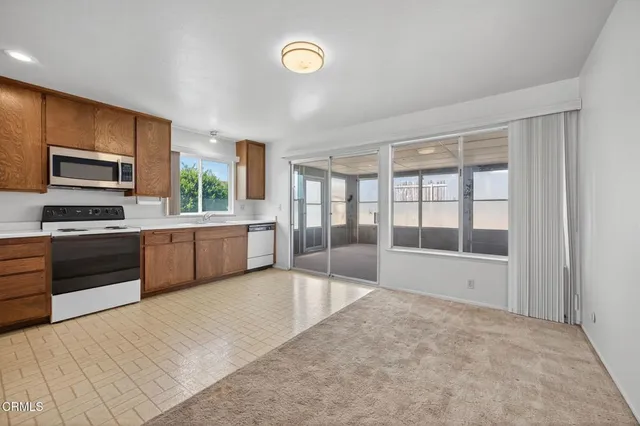 a large white kitchen with a stove a sink and a refrigerator