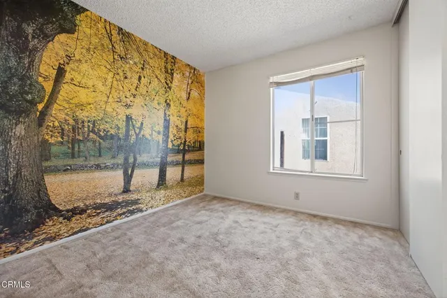 an empty room with a fireplace and large window