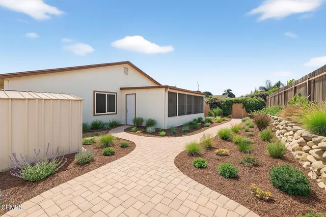 a front view of a house with a yard and a garden