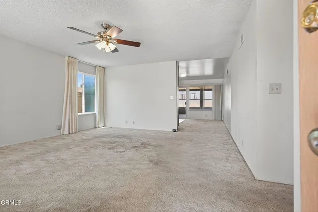 a view of an empty room with a chandelier fan