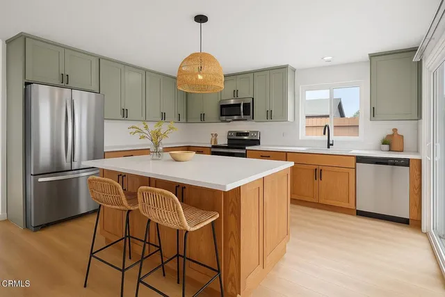 a kitchen with a sink a refrigerator and white cabinets