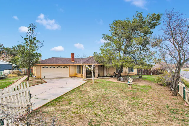 a view of a house with a yard and tree s