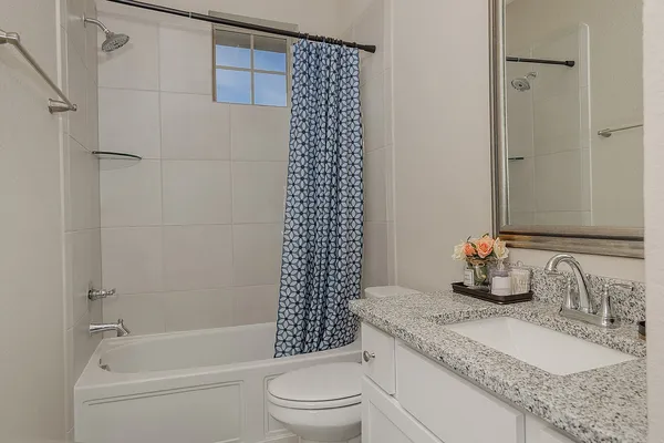 a bathroom with a granite countertop sink toilet and shower