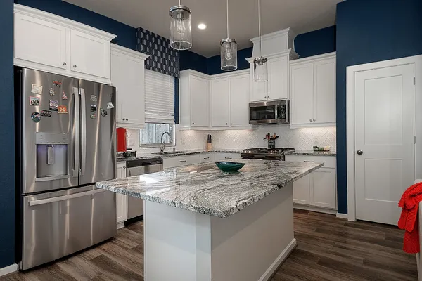 a kitchen with stainless steel appliances granite countertop a sink stove and refrigerator