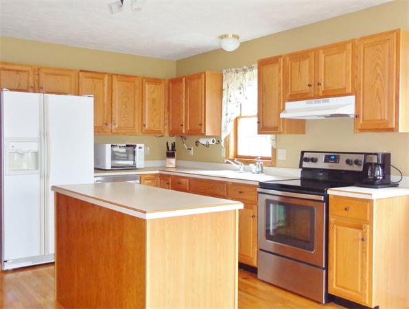 43 Old Poor Farm Road Ware, MA 01082 - Photo 12 of 29 a kitchen with stainless steel appliances a stove a sink and white cabinets with wooden floor