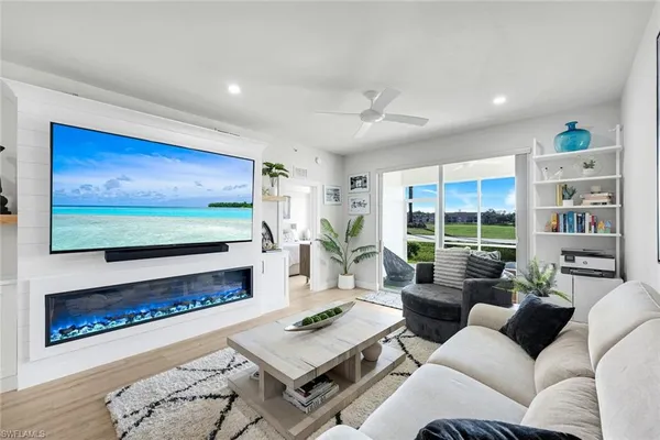 a living room with furniture a flat screen tv and a fireplace