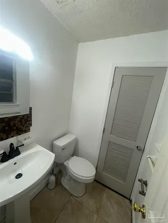 a bathroom with a toilet a sink a mirror and vanity