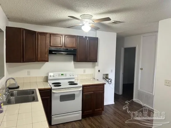 a kitchen with a stove cabinets and wooden floor
