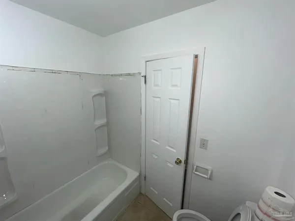 a bathroom with a granite countertop toilet and a shower